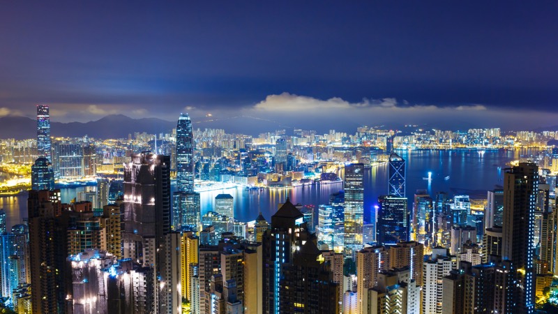 Harbor city skyline at night representing a long-held real estate position