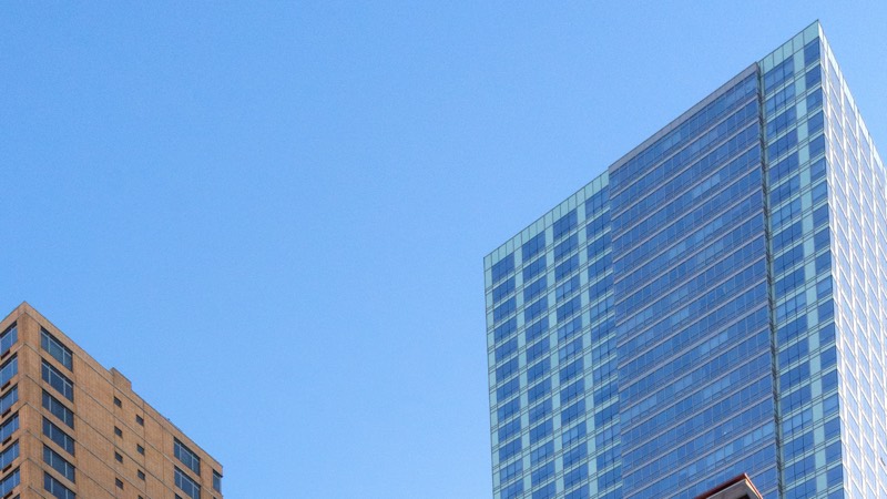 Modern glass office building against a clear sky