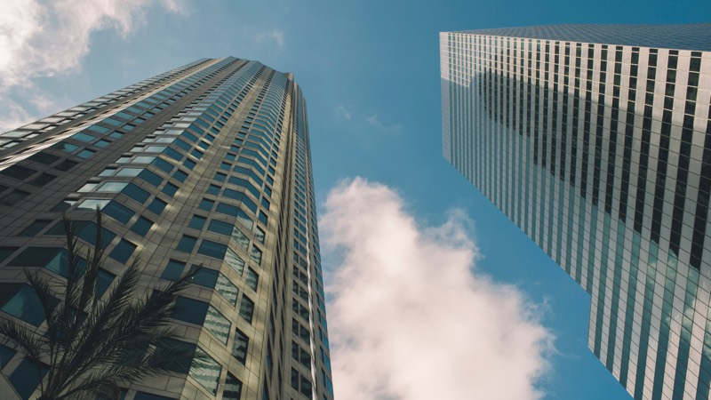 Twin office towers rising into cloud cover